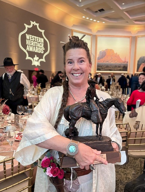 Karla K Morton holding Wrangler award from National Cowboy & Western Heritage Museum at 65th Western Heritage Awards.
